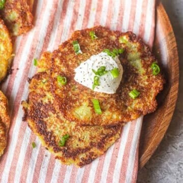 Deruny on striped mat topped with sour cream and green onions.