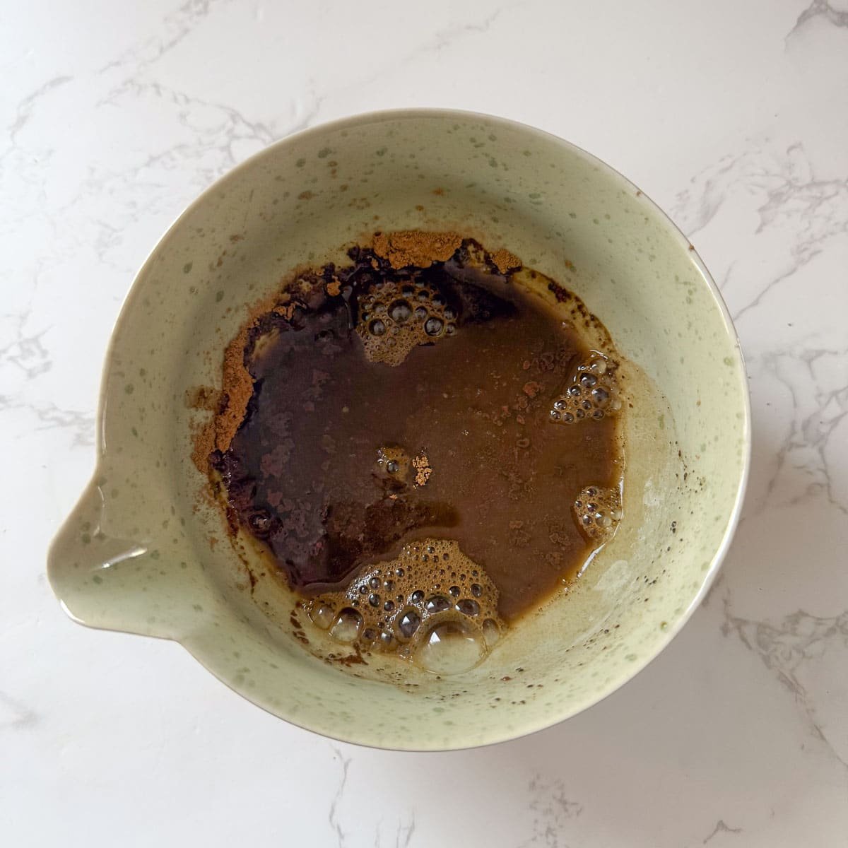 hojicha in bowl with water before mixing.