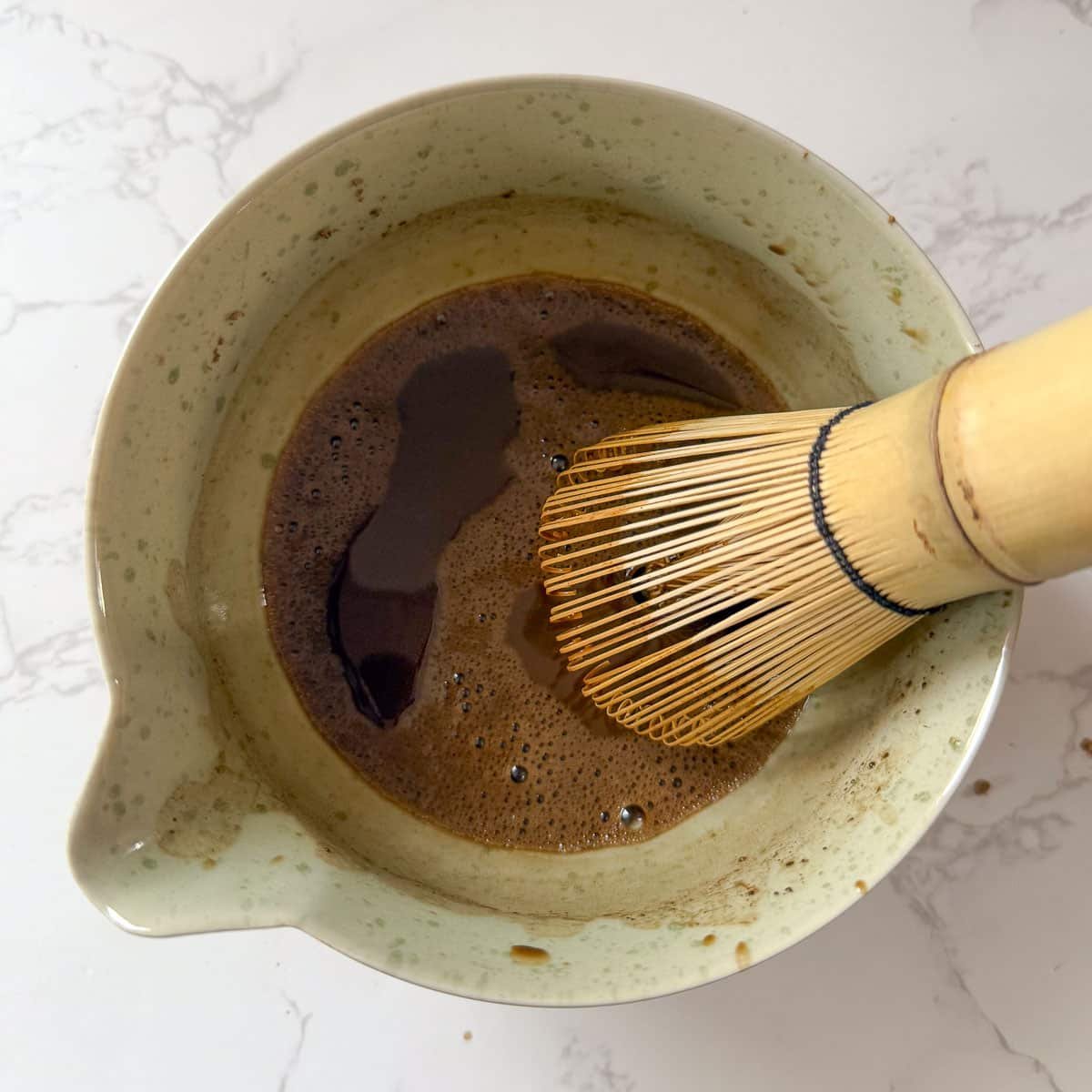 hojicha being mixed with bamboo whisk.
