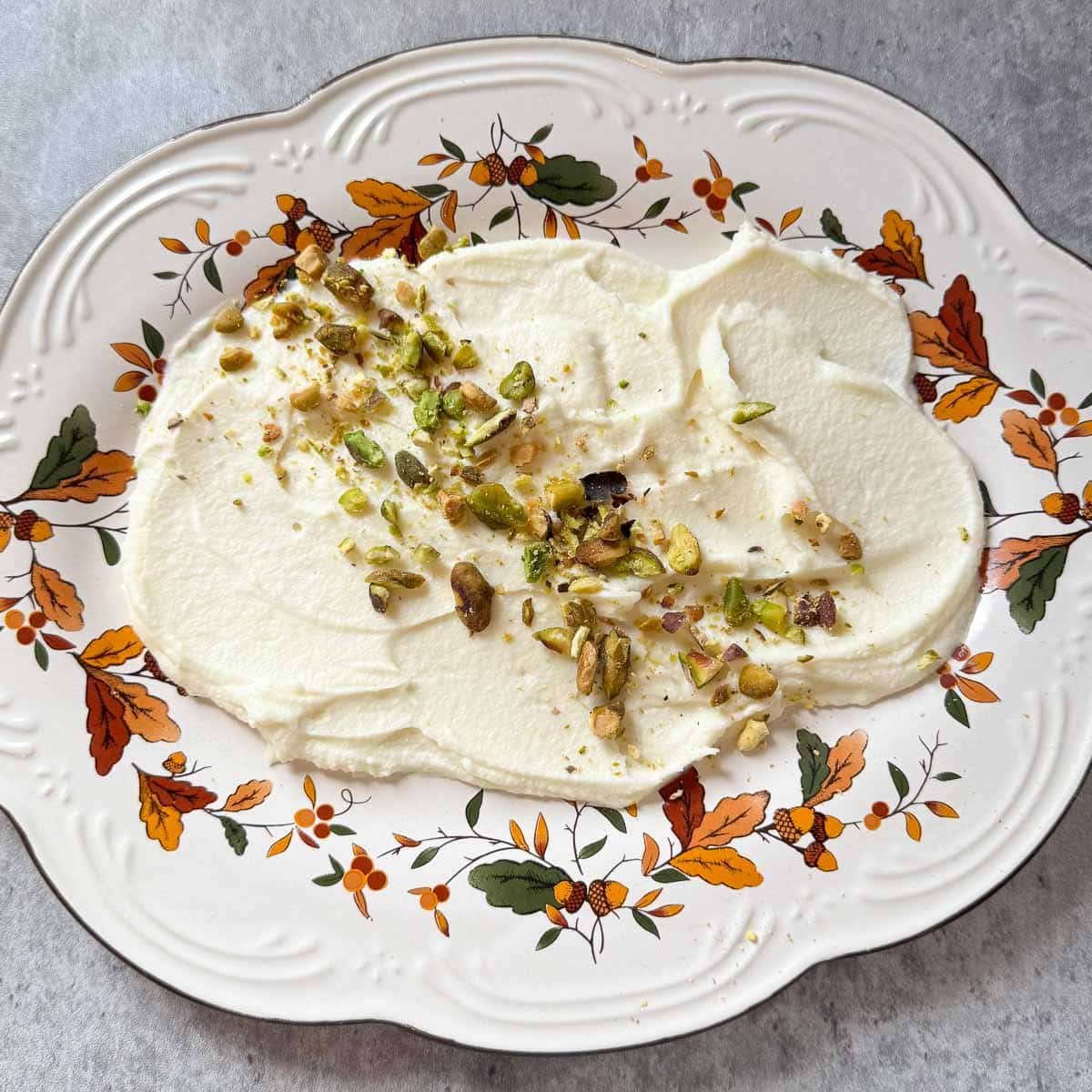 plate with mascarpone and crumbled pistachio base.