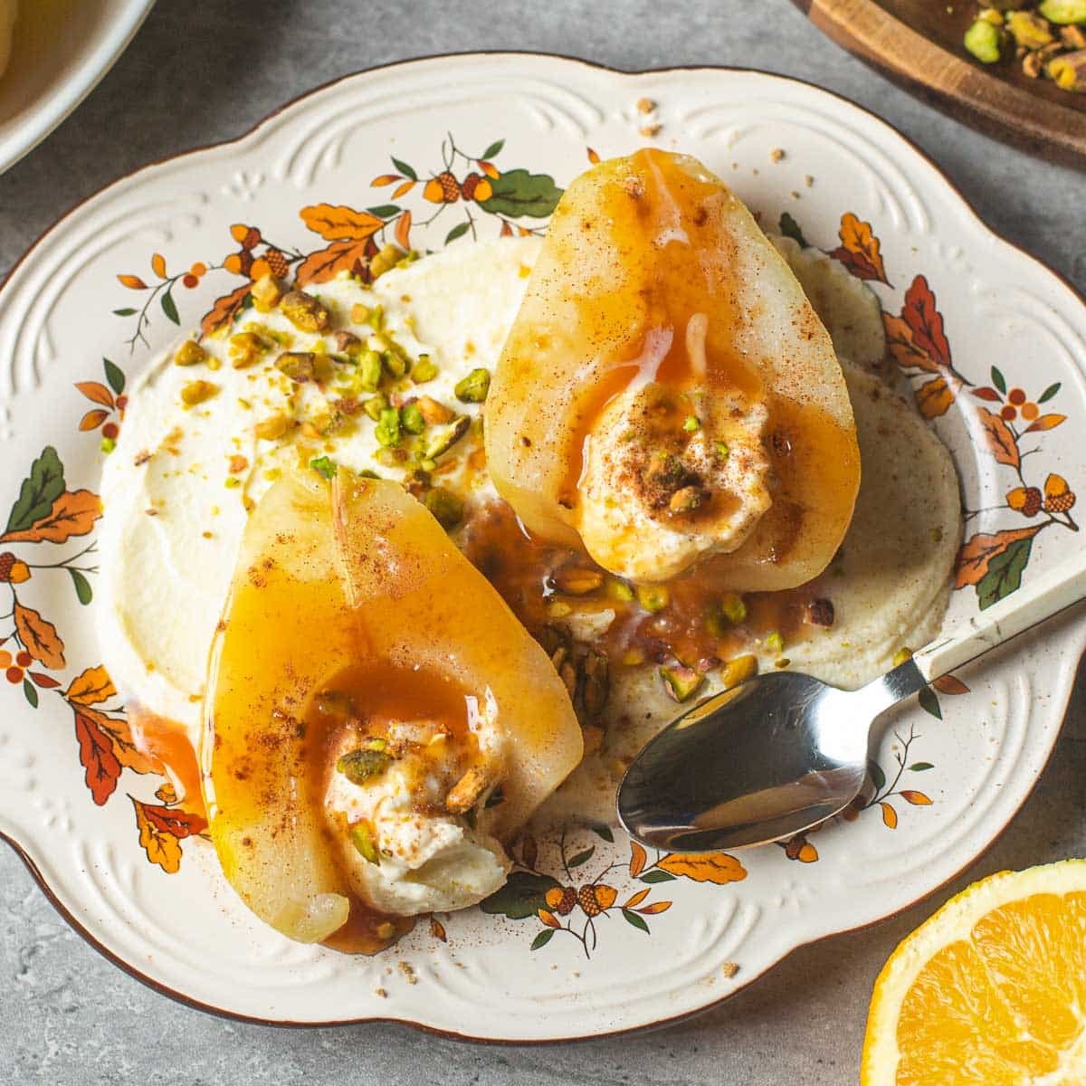 poached pears atop mascarpone surrounded beside orange.