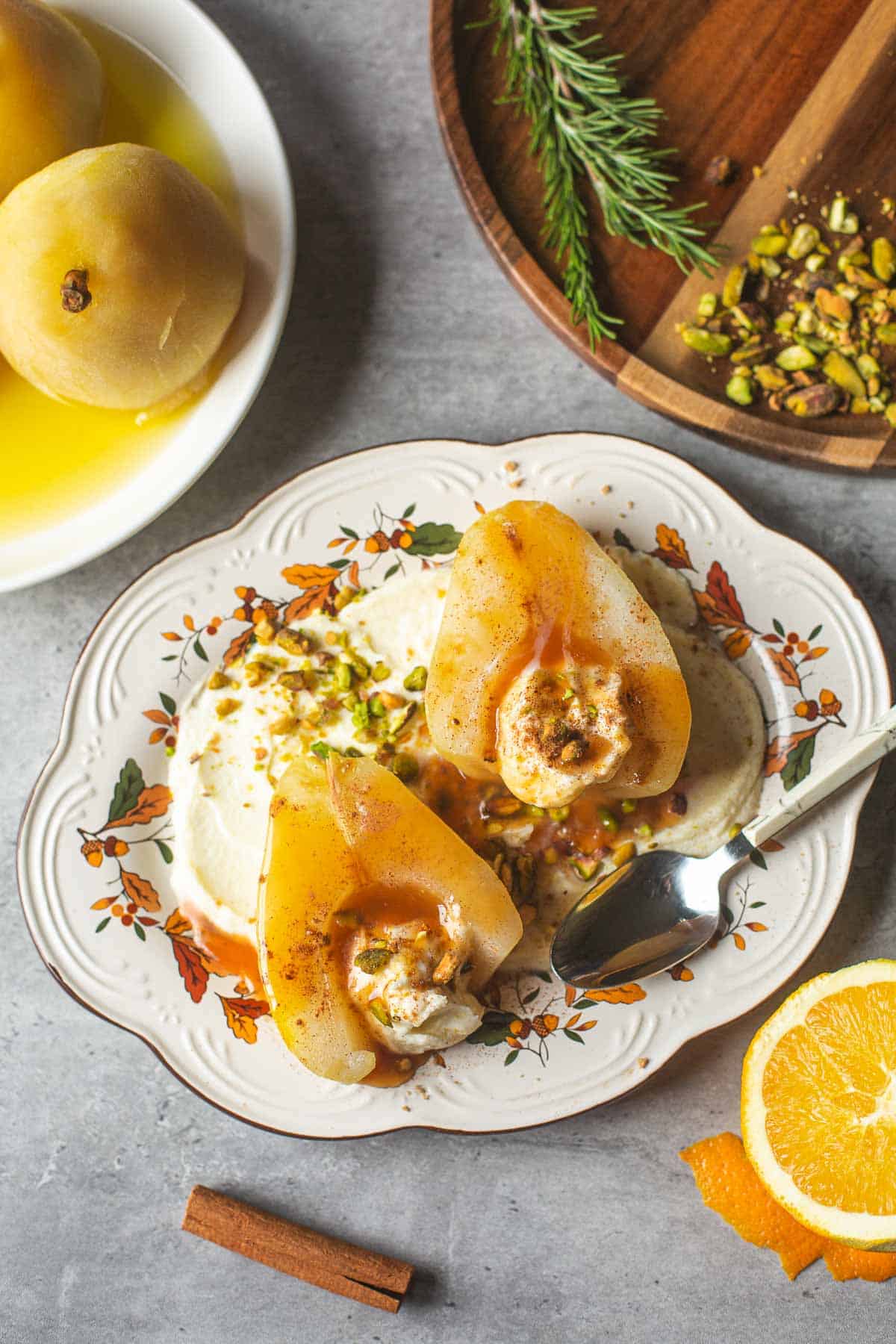 poached pears atop mascarpone surrounded by pears, orange, cinnamon, pistachios.