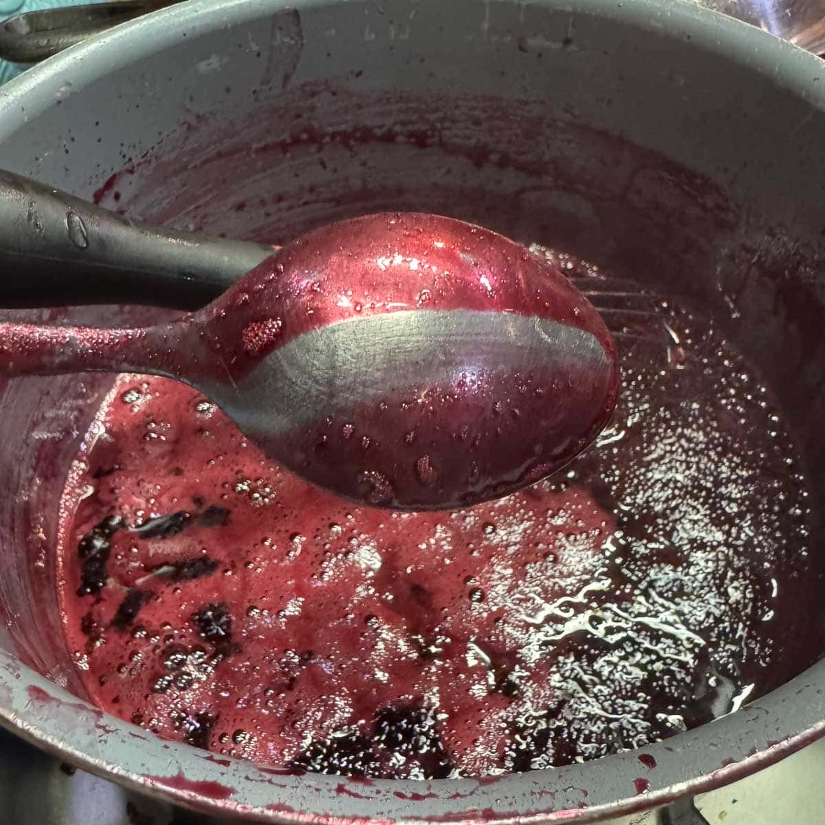 back of spoon coated in pomegranate syrup.