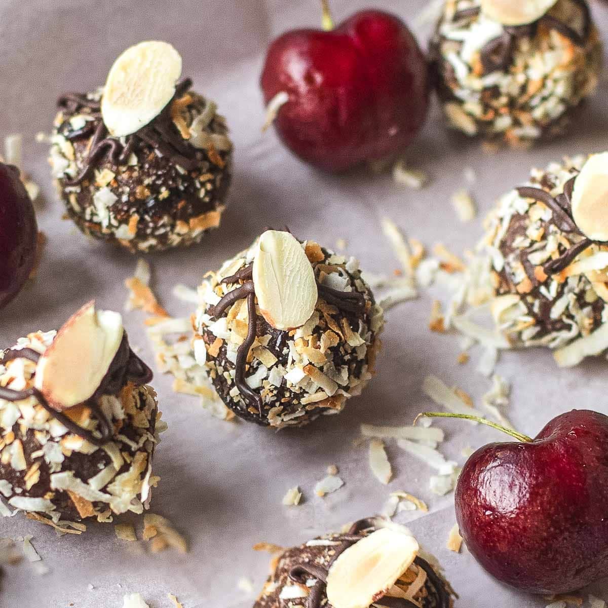 bliss balls on tray beside fresh cherries.