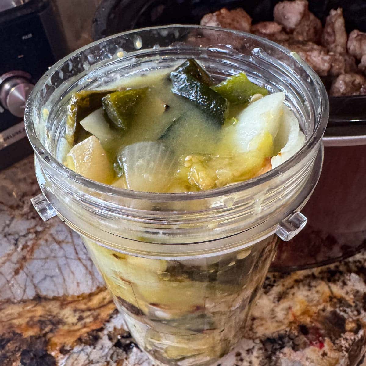 chopped roasted veggies in a measuring cup before being blended