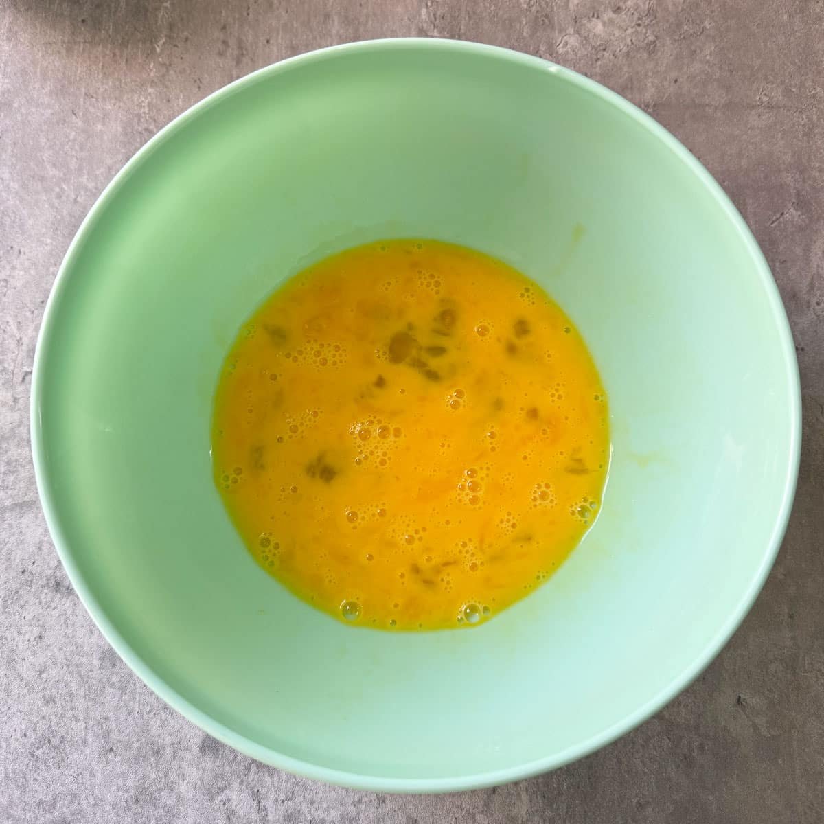 whisked eggs in green bowl
