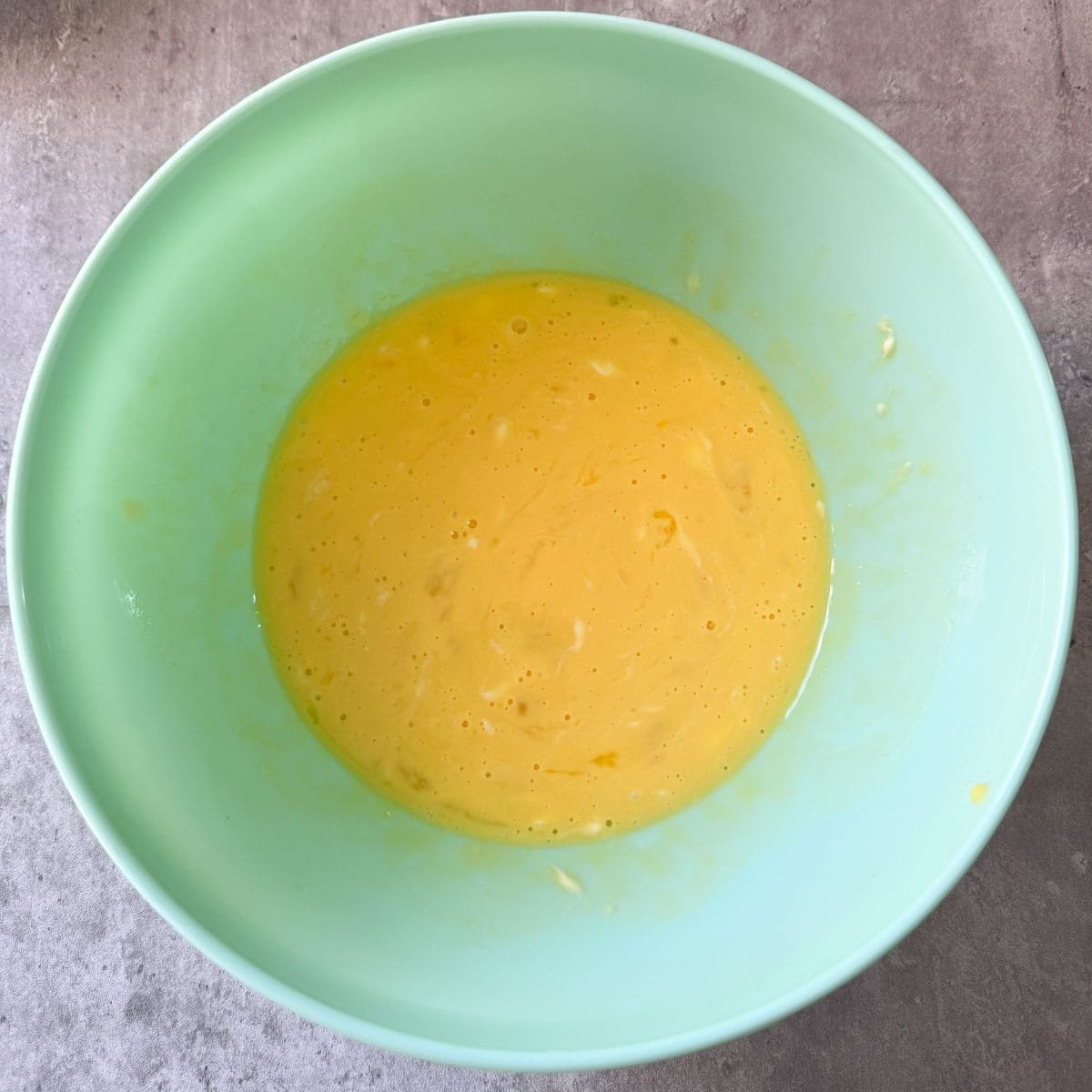 egg & creme mixture after being combined in a green bowl