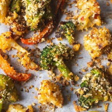 roasted broccoli, cauliflower, and red peppers on baking sheet.