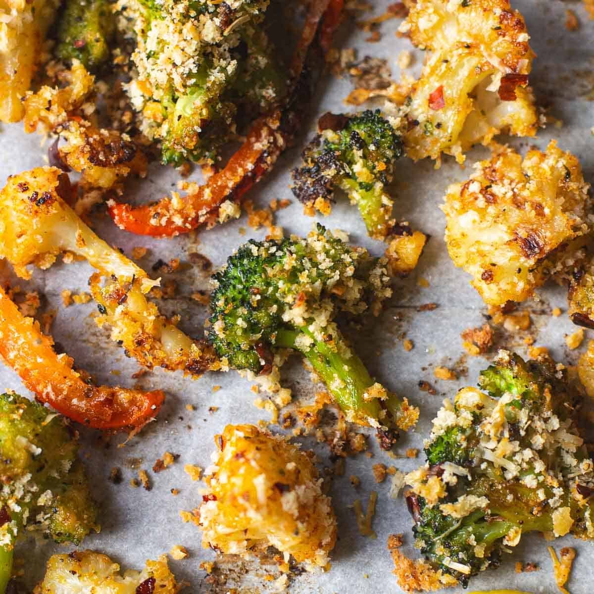 roasted broccoli, cauliflower, and red peppers on baking sheet.