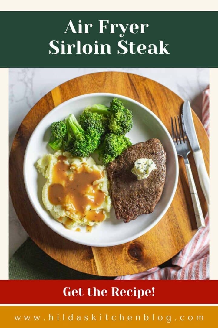 air fryer sirloin steak topped with herb butter beside broccoli, mashed potatoes, and utensils.