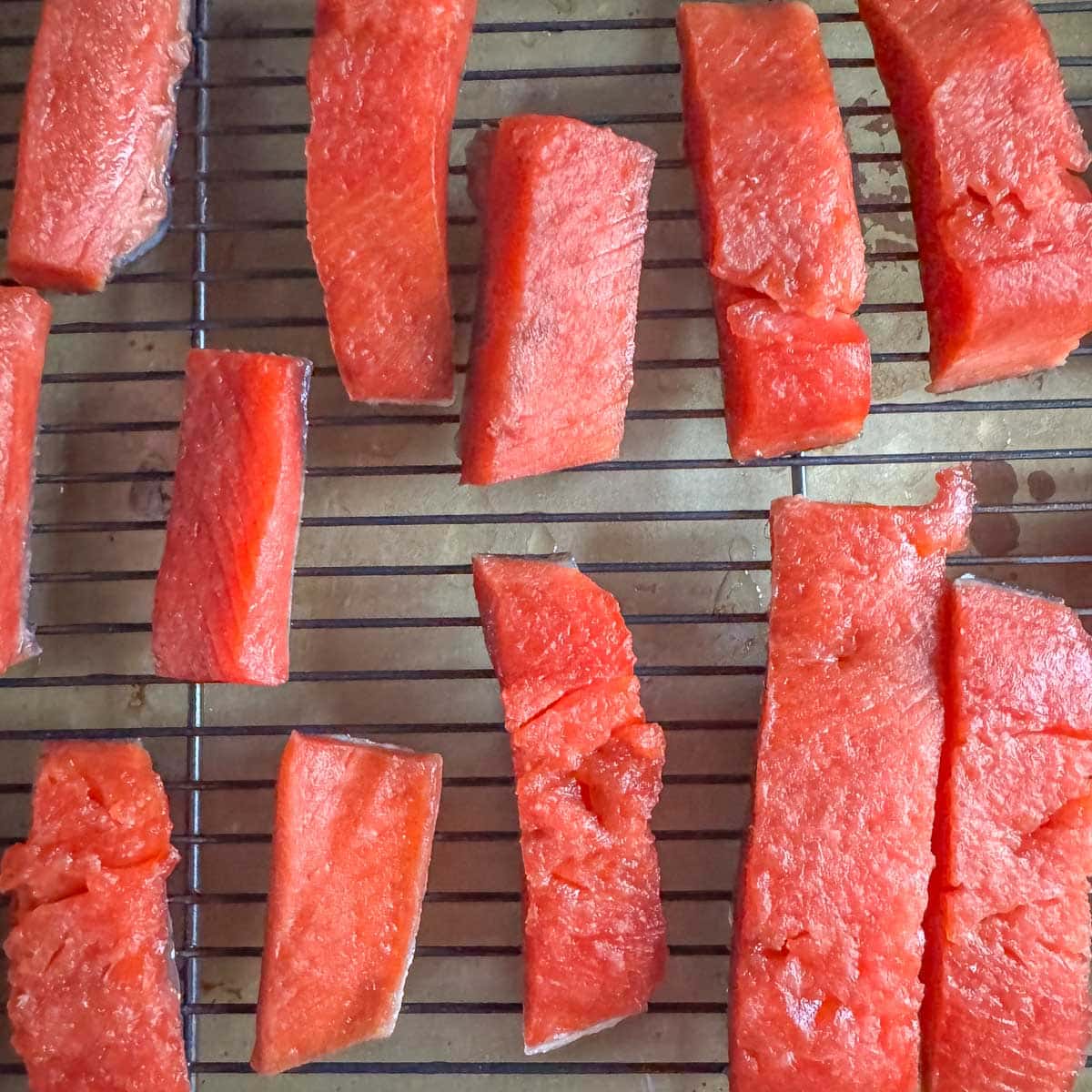 salmon strips on a rack over a tray