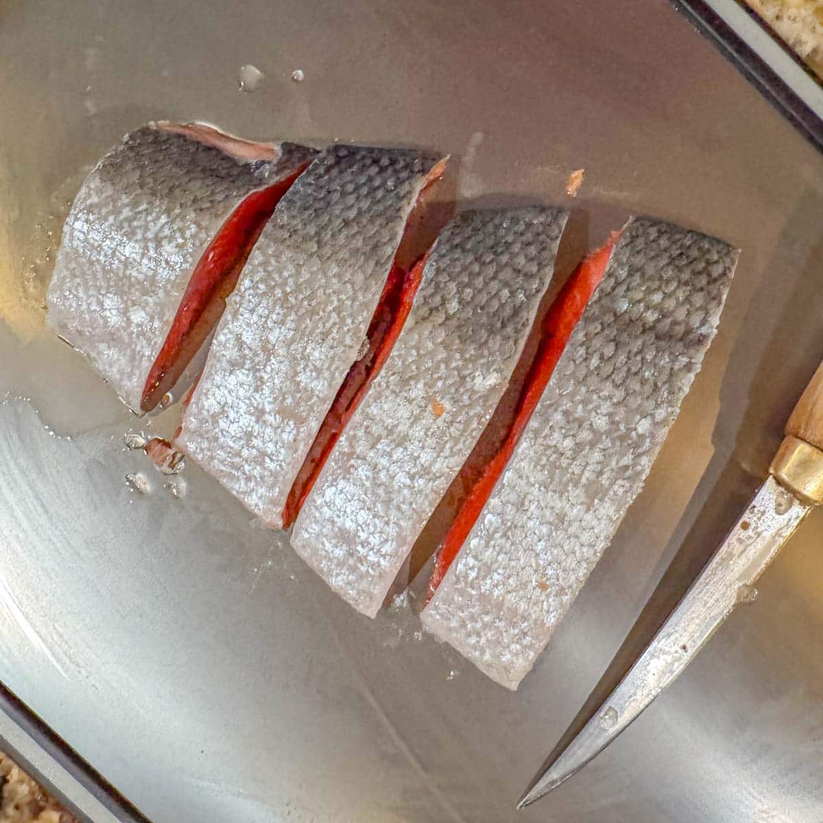 sliced salmon with a knife next to it