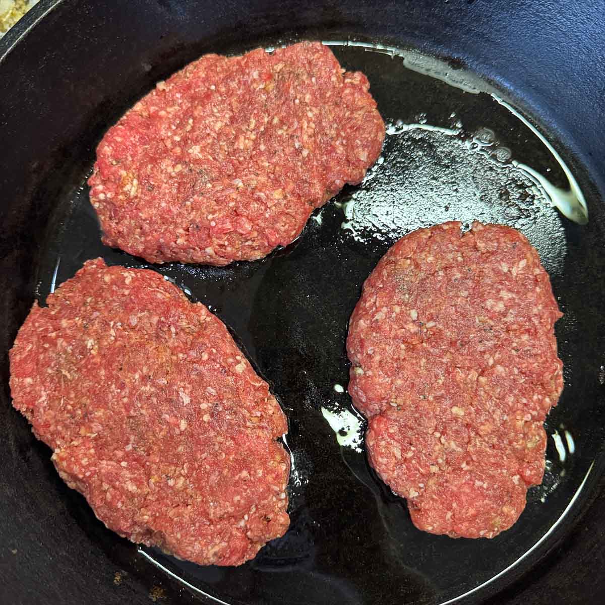raw Salisbury steak in a skillet