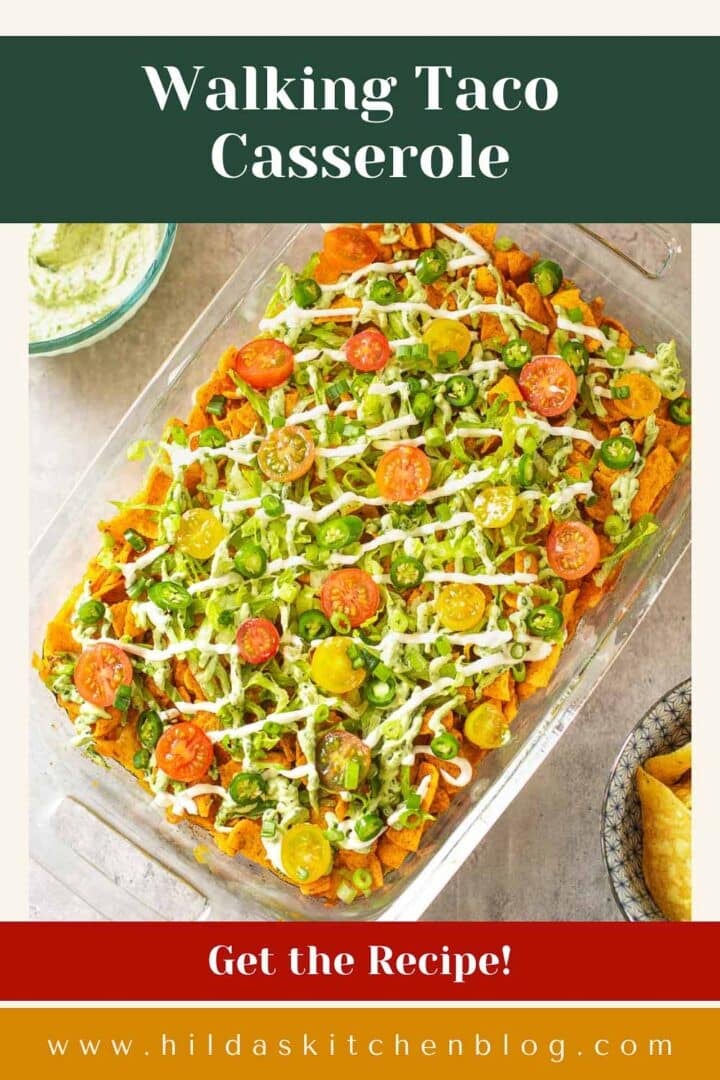 walking taco casserole in baking dish beside bowl of cilantro crema and bowl of chips.