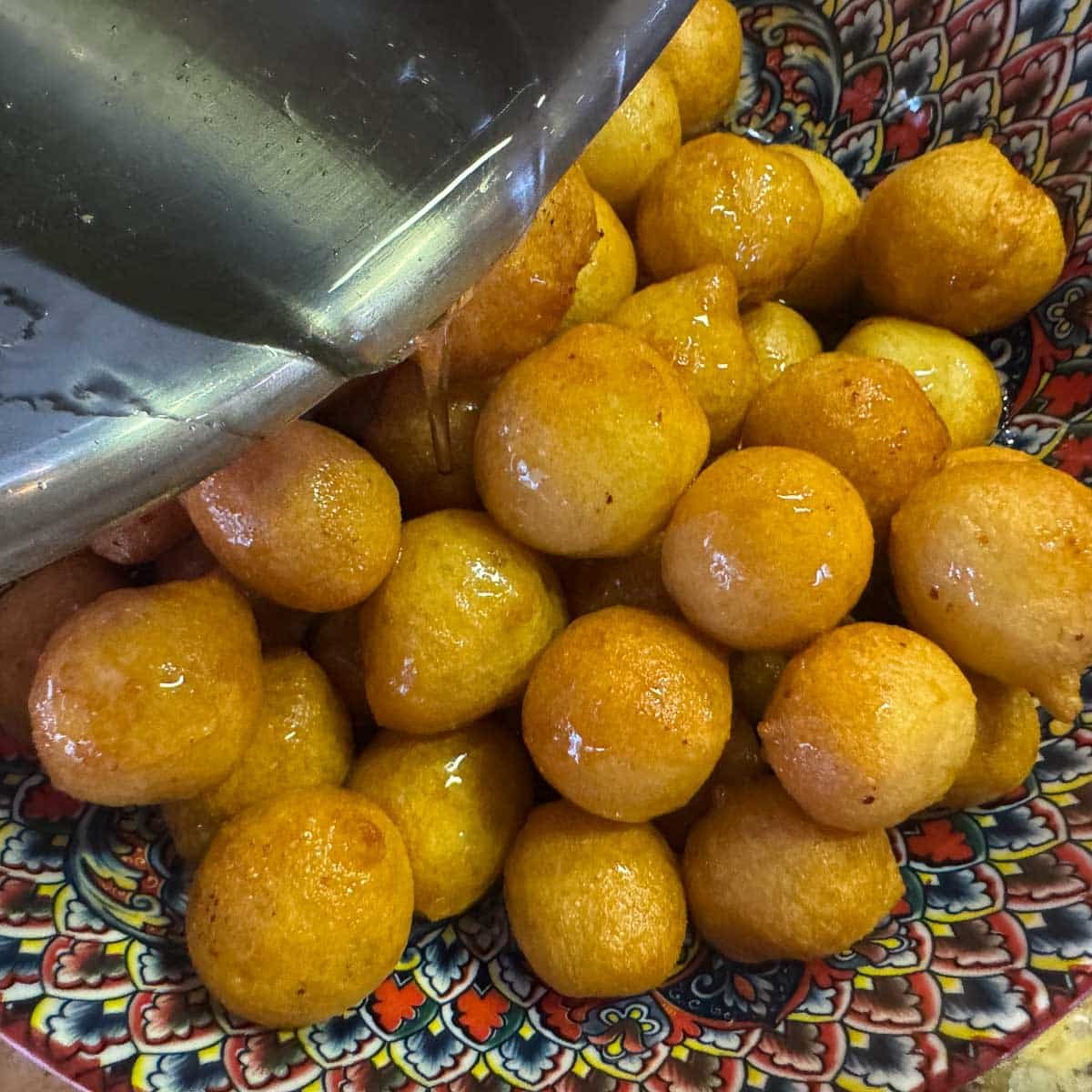 luqaimat being drizzled with syrup