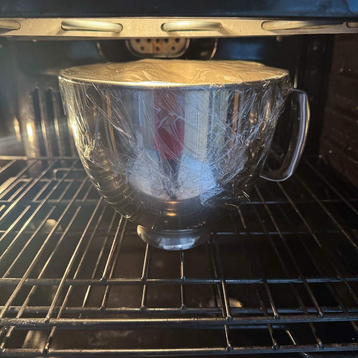 mixer bowl with dough, proofing in the oven