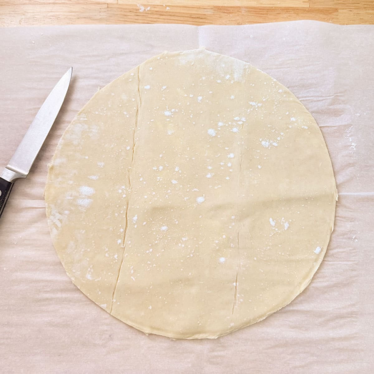 puff pastry cut into a circle beside paring knife.