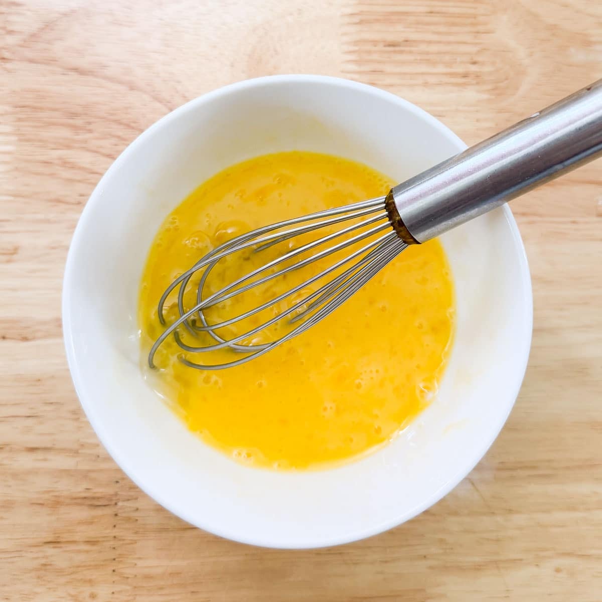 egg wash in bowl with whisk.
