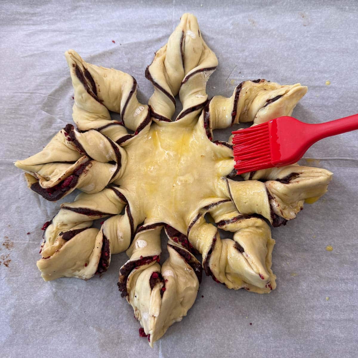 silicone brush coating chocolate pastries with egg wash.