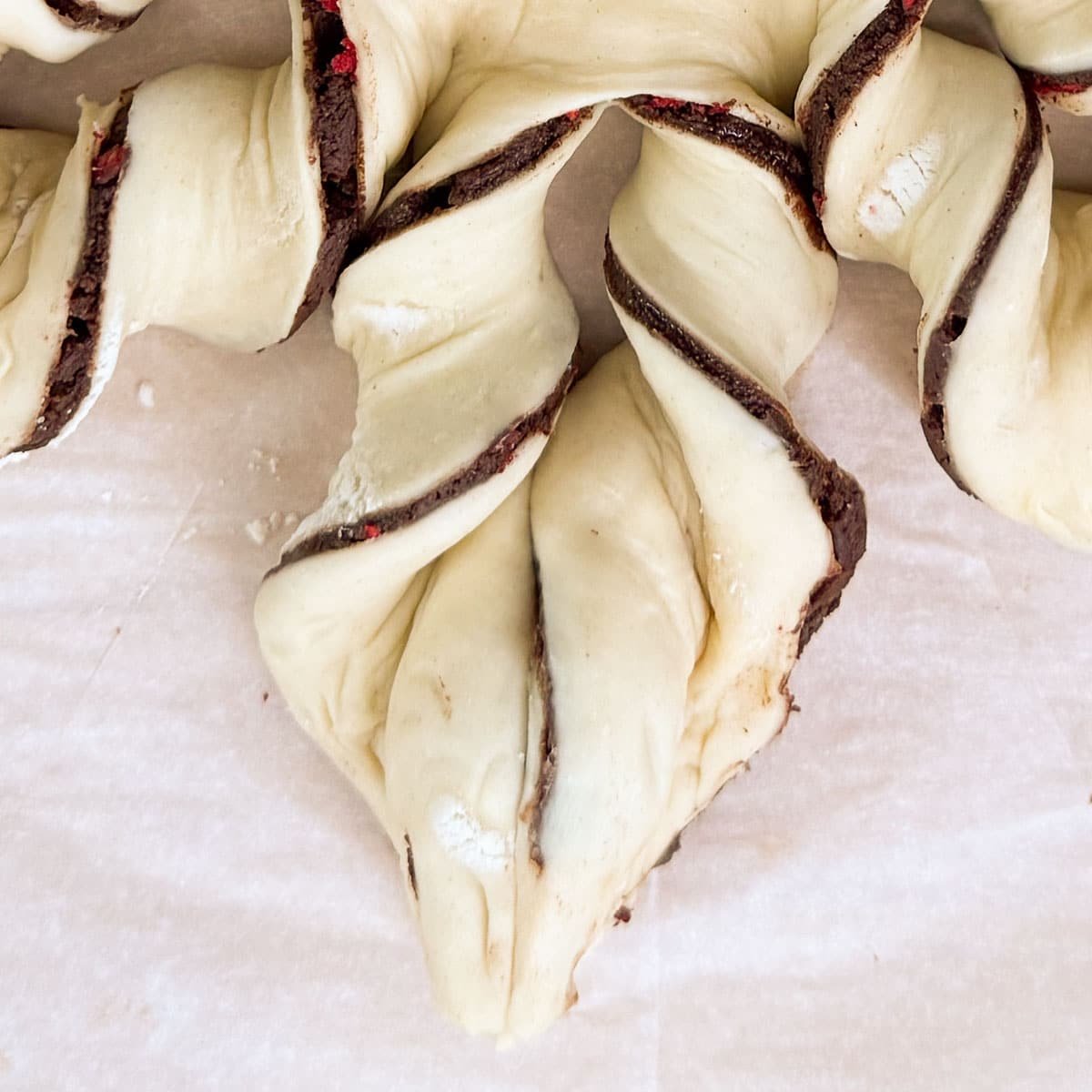 two strips of the chocolate puff pastry twisted to form a point on the snowflake.