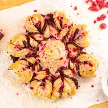 snowflake-shaped chocolate puff pastry with chocolate, freeze-dried raspberries, and raspberry glaze.