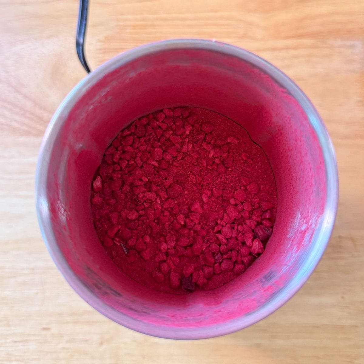 powdered freeze dried raspberries in spice grinder after processing.