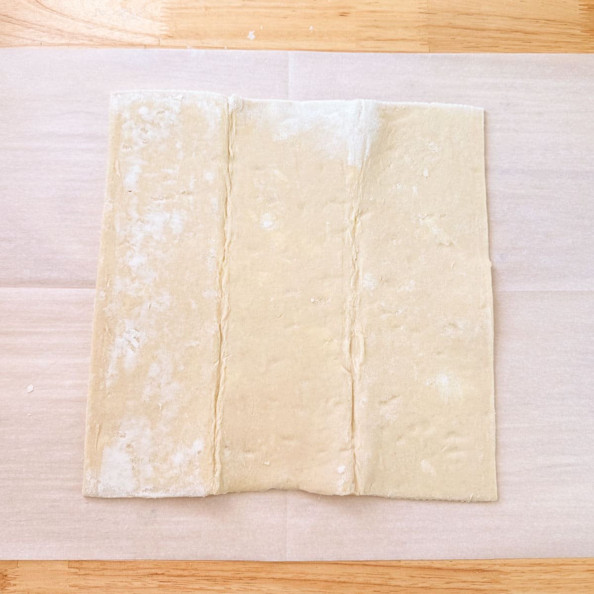 puff pastry sheet on parchment paper before rolling.