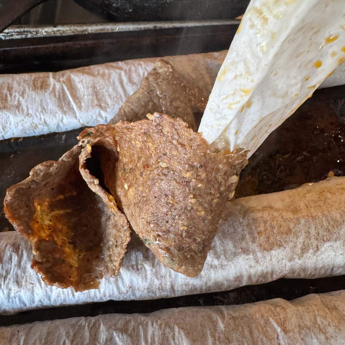 unrolling sheets of cooked doner kebab