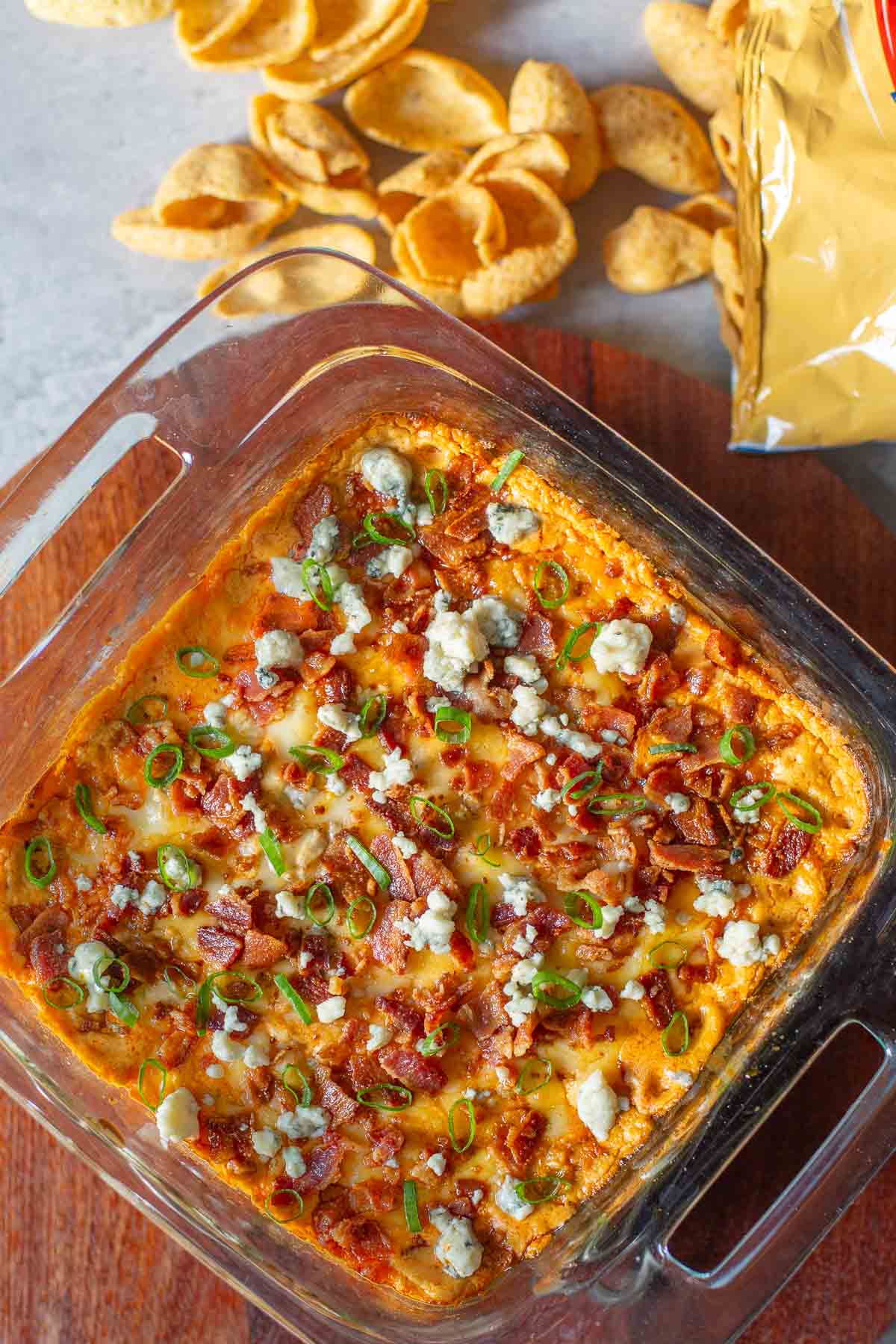 buffalo chicken dip in pan beside corn chips.