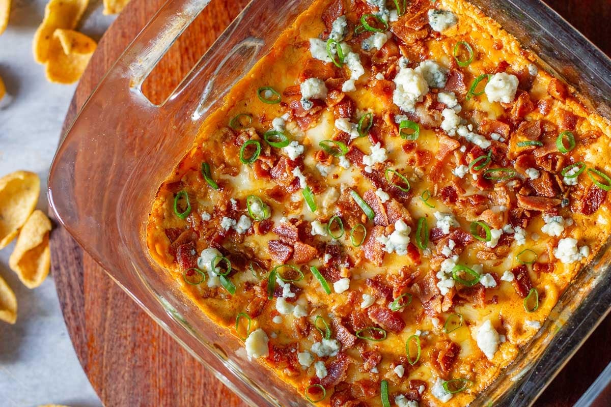 buffalo chicken dip in pan beside corn chips.