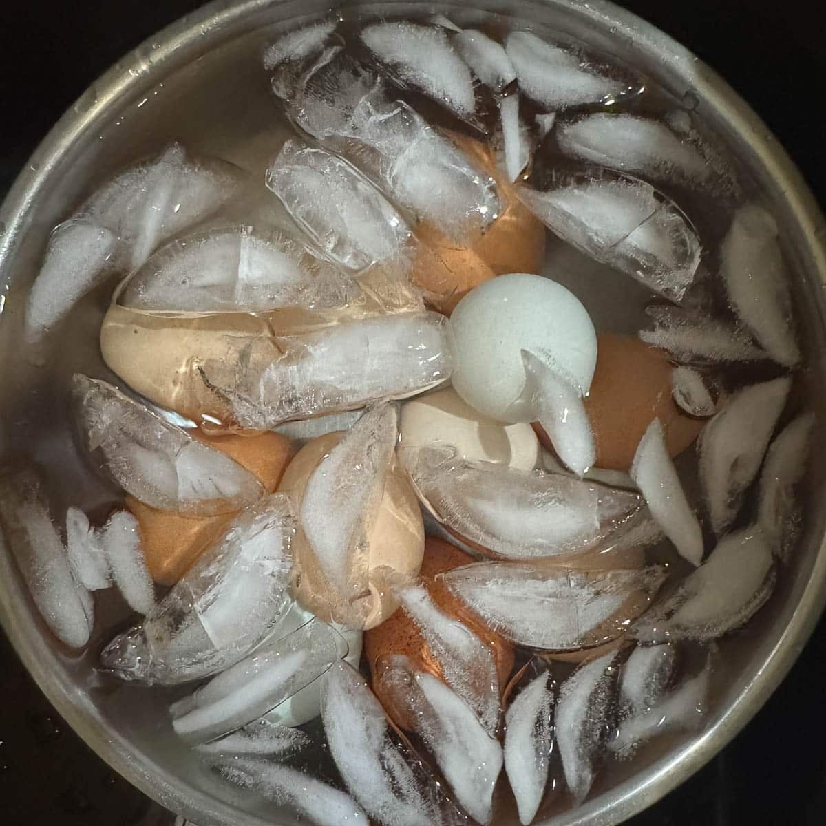 water and ice in a bowl with colorful eggs