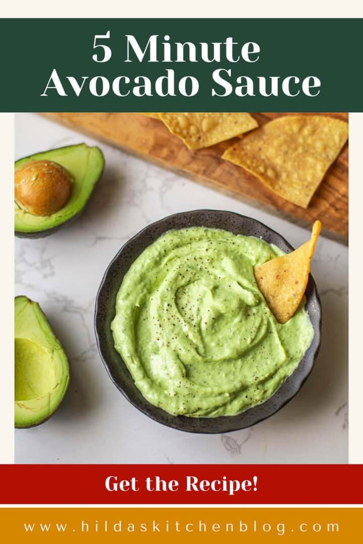 avocado sauce with chip dipped beside halved avocados and cutting board with lime & chips.