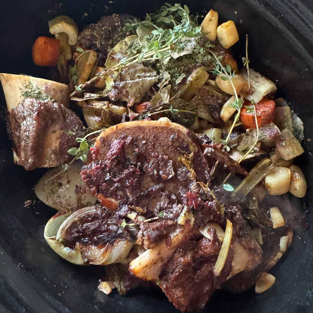 roasted bones, veggies and herbs in a slow cooker