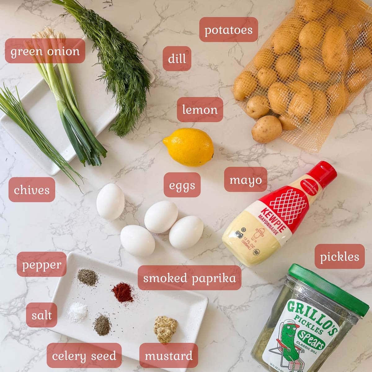 Dill pickle potato salad ingredients including potatoes, eggs, dressing, herbs, pickles, and spices.