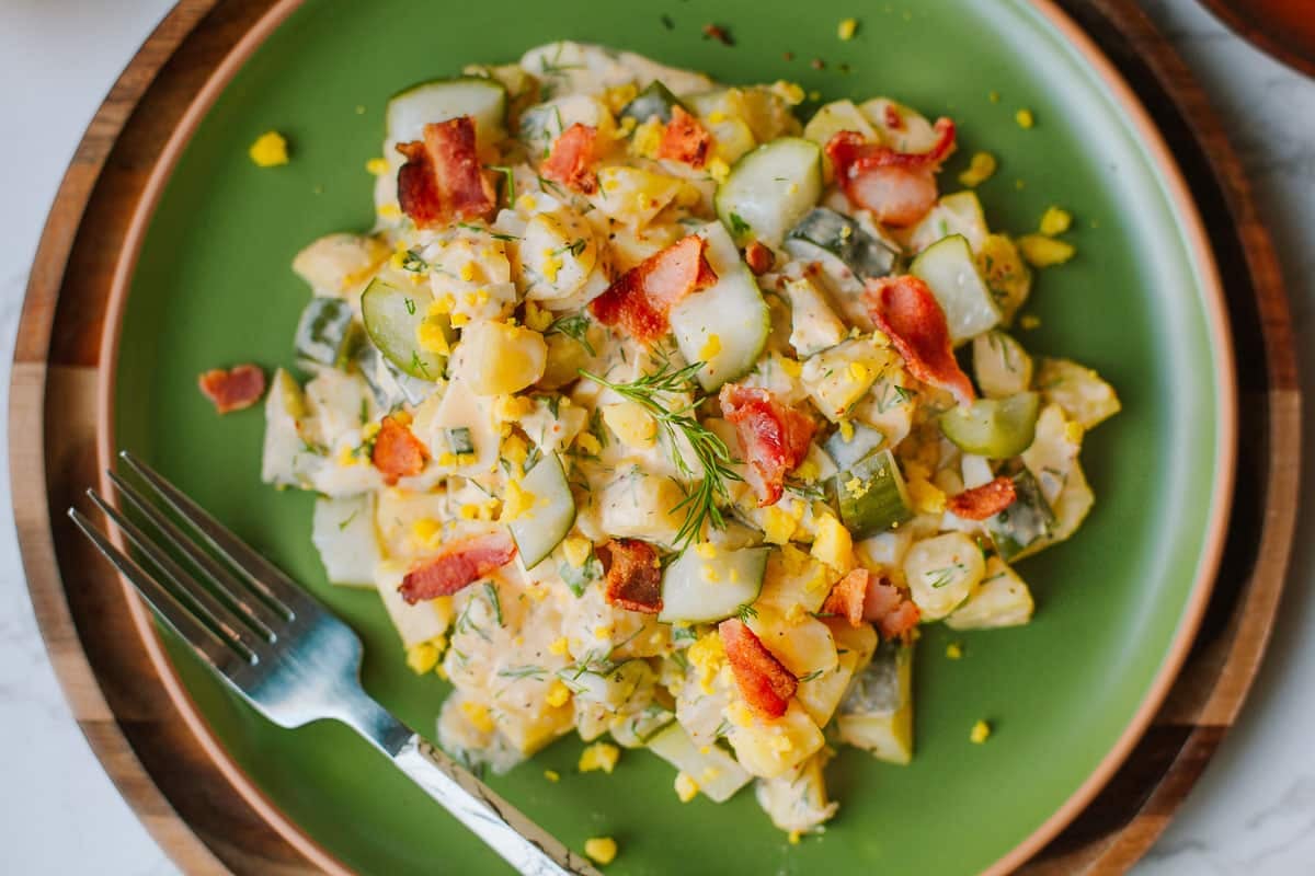 Dill pickle potato salad on a green plate