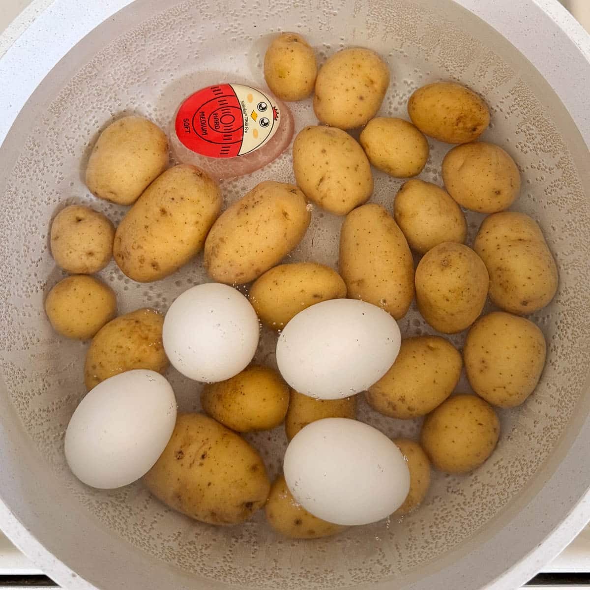 a pot of potatoes and eggs in getting boiled together
