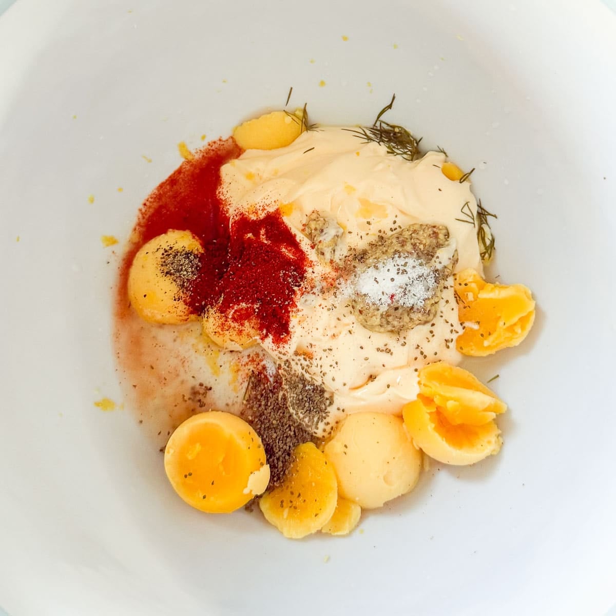 dill pickle potato salad dressing ingredients in a white bowl