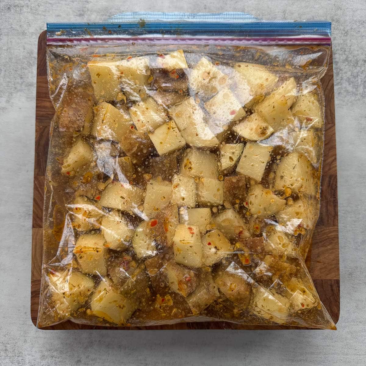 cubed potatoes in a plastic bag full of marinade