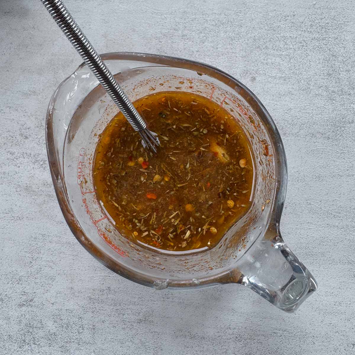 marinade in a measuring cup with a small whisk