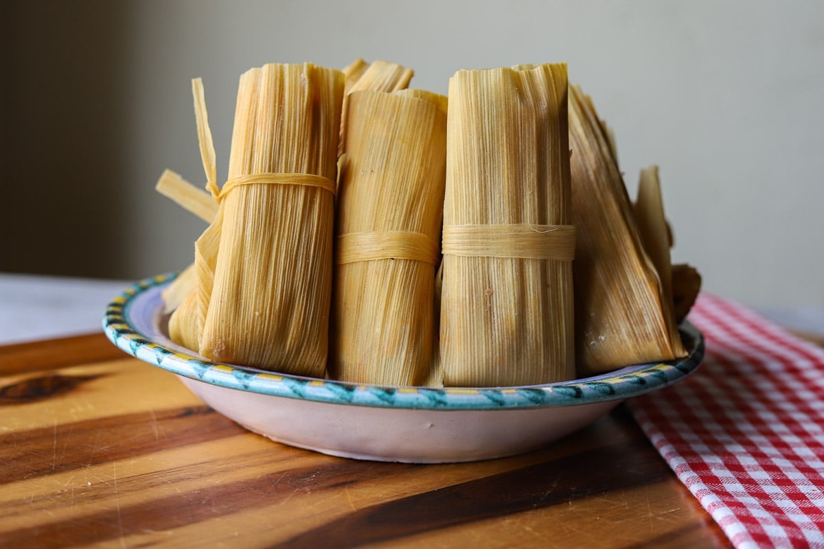 beef tamales in a plate with a red and white checkard towel