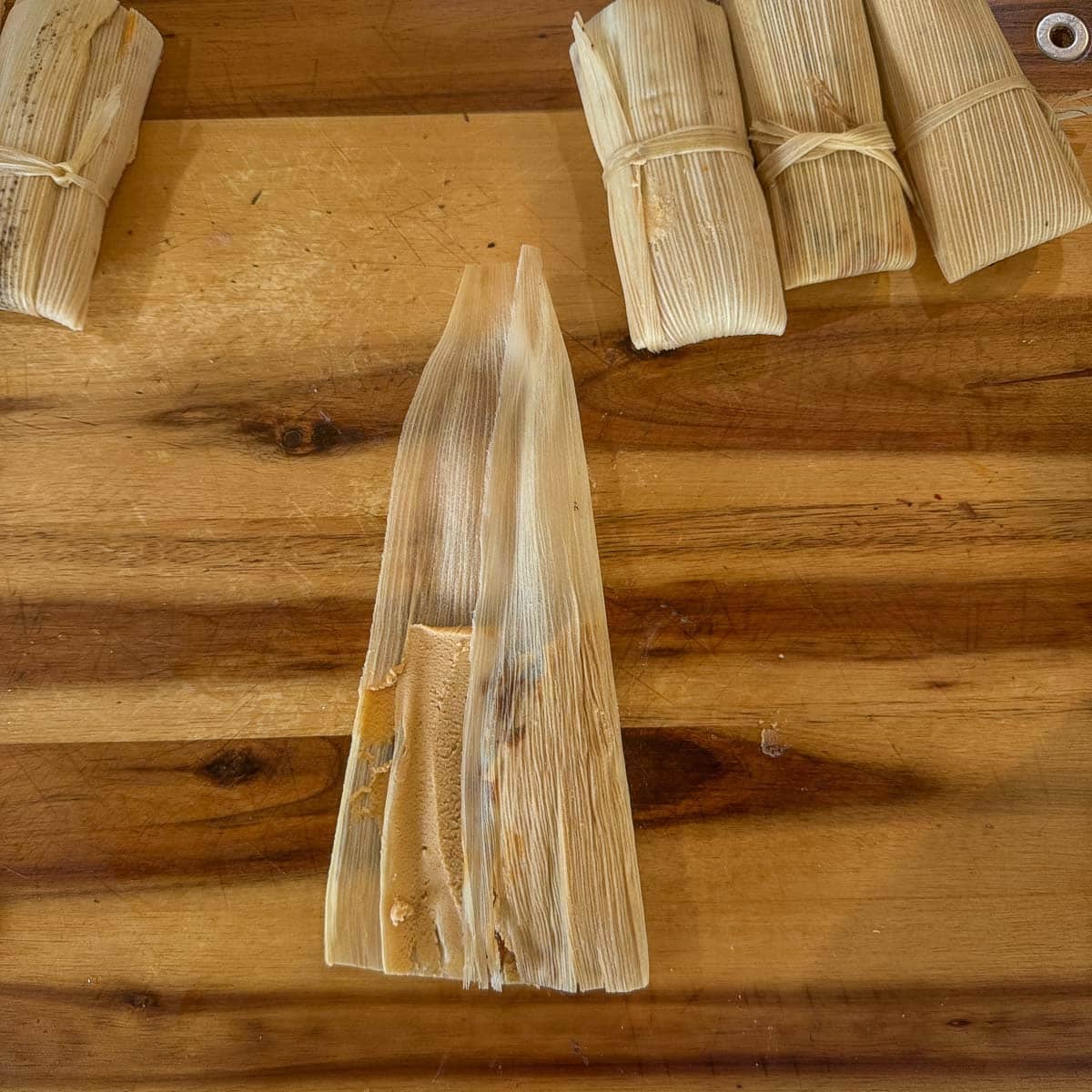 corn husk with tamale partially folded