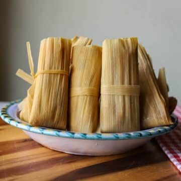 beef tamales in a bowl over a wooden cutting board