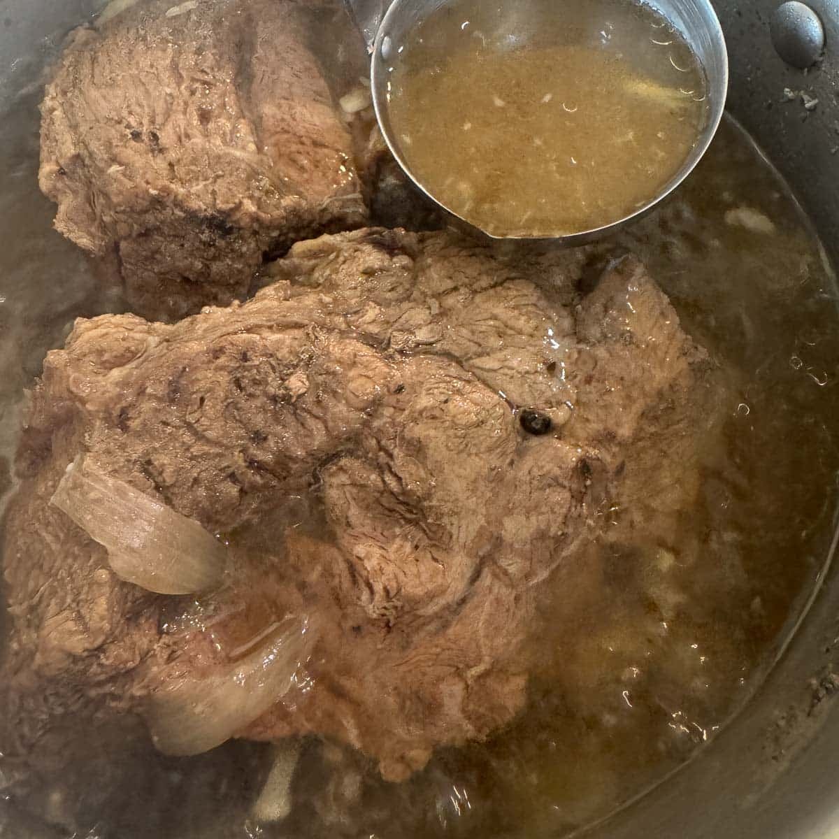 cooked beef roast in a pot of liquid