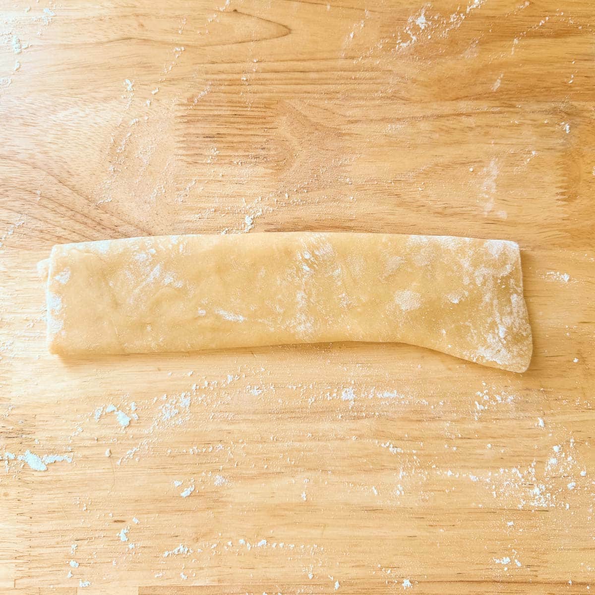 thinly rolled homemade egg noodle dough folded into 4 layers.