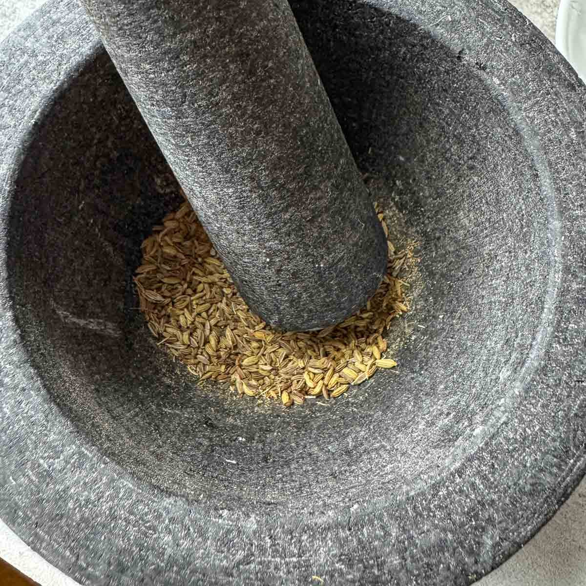 grinding seeds in mortal and pestle