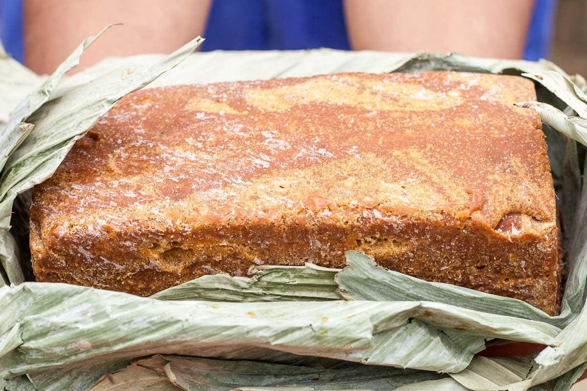 block of panela loosely wrapped in plant matter.