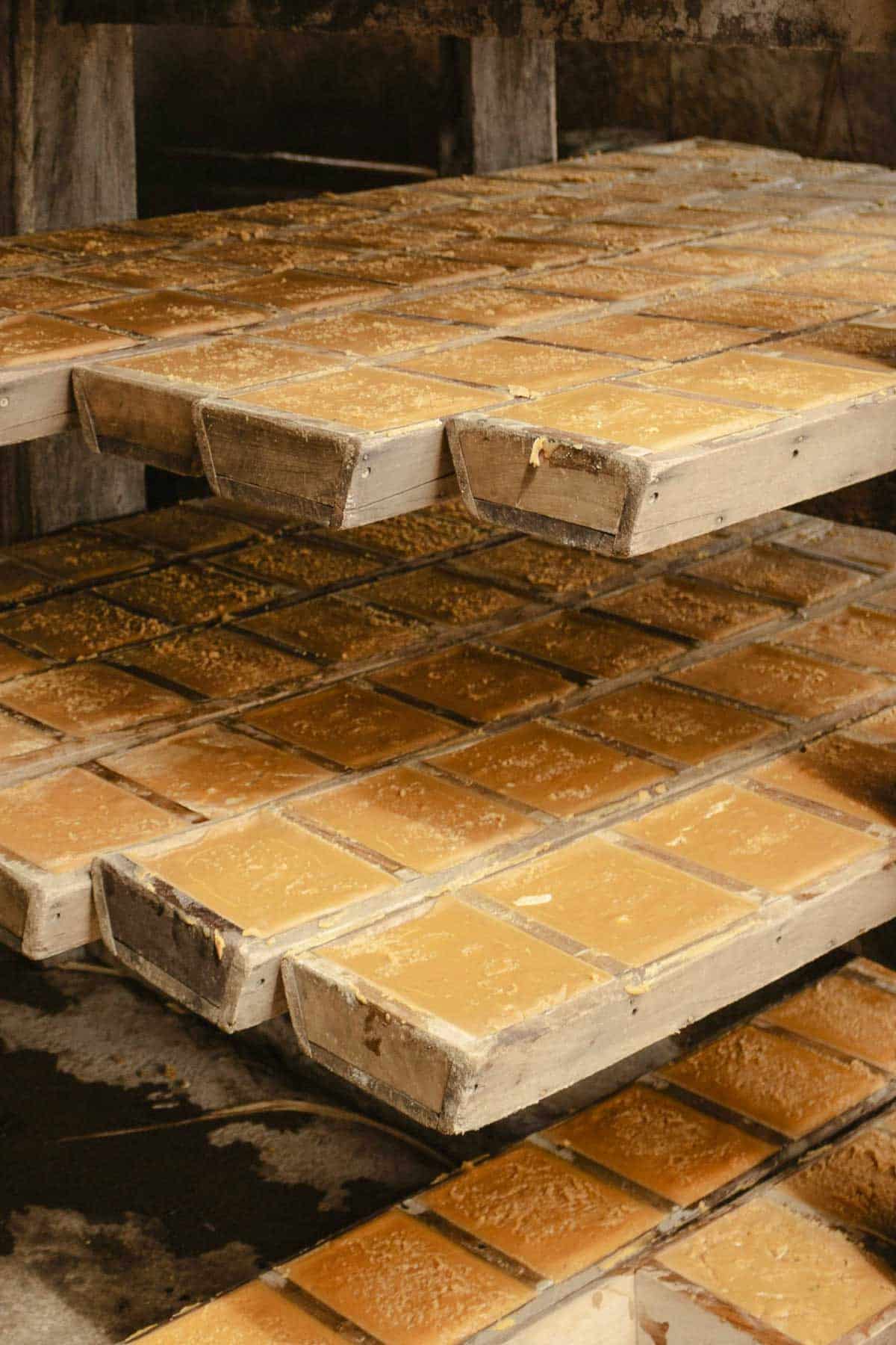 rapadura in brick-like molds on tiered shelves in Brazil.