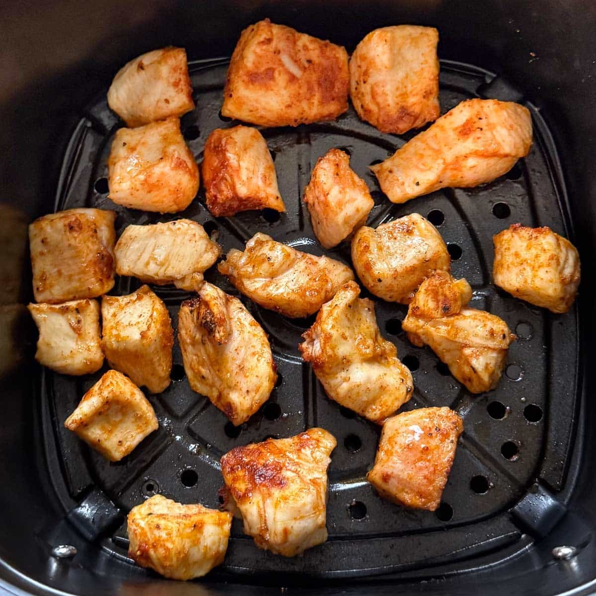 cooked cubed BBQ chicken in air fryer basket before adding sauce.