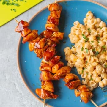 air fryer bbq chicken on skewers beside mac and cheese.
