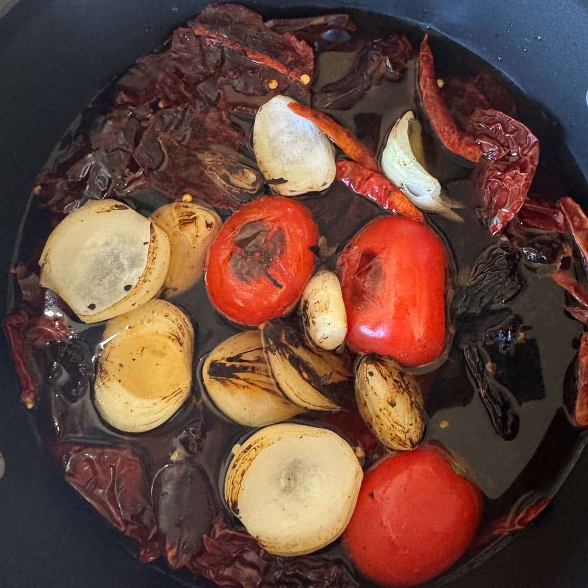 tomatoes, chiles, onion, and garlic simmering in water